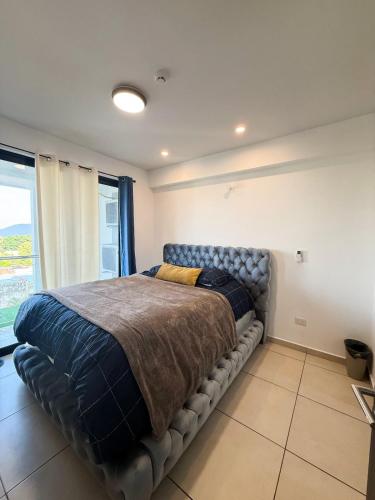 a large bed in a room with a large window at Bostor Apartament in San Salvador