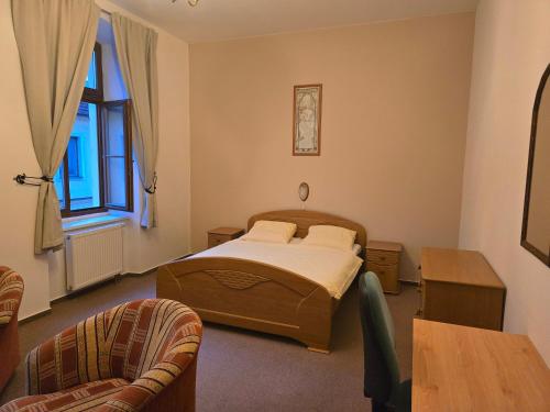 a bedroom with a bed and a table and chairs at Hotel Corso T-X in Rokycany