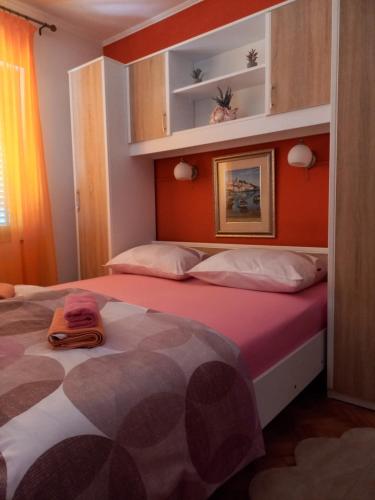 a bedroom with a large bed with an orange wall at Apartment Maya in Banjole