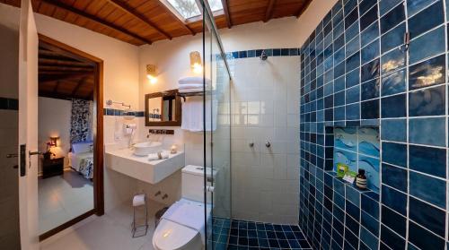a bathroom with a shower and a toilet and a sink at Villa Baobá Pousada & Spa in Búzios