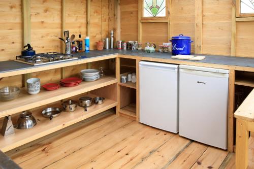 a kitchen with wooden floors and a white refrigerator at Yurt Ash tree in Saint Briavels