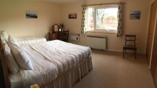 a bedroom with a bed and a window and a chair at Cairn Shiel in Achnasheen