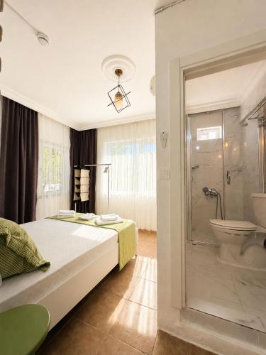 a bedroom with a bed and a shower and a toilet at Hil Ada 1 in Bozcaada