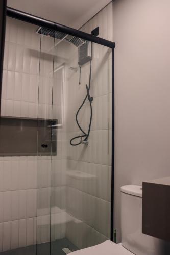 a glass shower in a bathroom with a toilet at TBG Studios in Curitiba