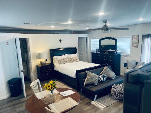 a bedroom with a bed and a table and a couch at Serenity home in Laplace
