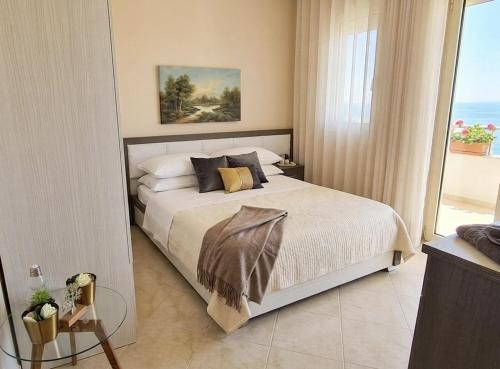 a bedroom with a bed and a large window at Marina Chic Apartment in Vlorë