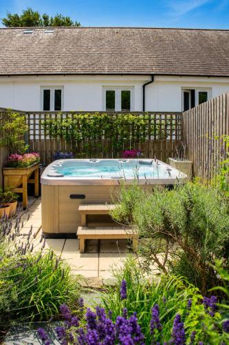 a hot tub in the middle of a garden at Meadowvine - By Rowes Retreats in Penryn