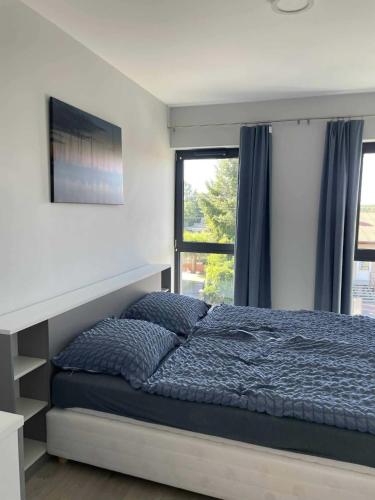 a bedroom with a bed and a window at WidziMisie Summer Apartament in Dominice
