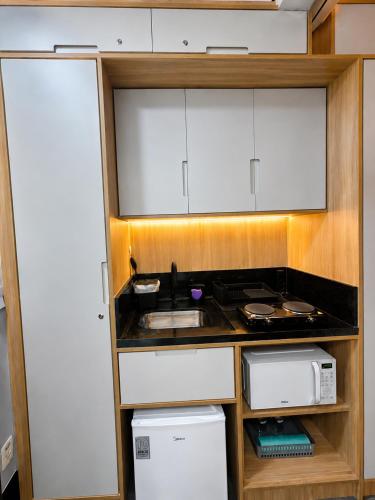a small kitchen with a sink and a microwave at Flat em Santos próximo a praia e Vila Belmiro in Santos