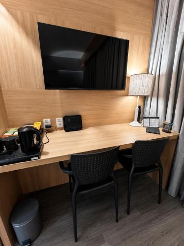 a desk in a hotel room with two chairs at Flat em Santos próximo a praia e Vila Belmiro in Santos
