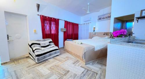 a bedroom with a bed and a bathroom with a sink at Hébergement H in Ngaring
