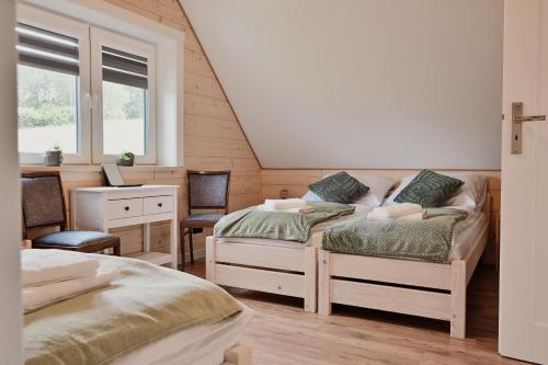 a bedroom with two beds and a desk and a window at Zdrojowe wzgórze in Rymanów-Zdrój