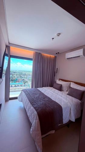 a bedroom with a large bed and a large window at Salinas Beach Resort in Salinópolis