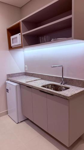 a kitchen counter with a sink and a microwave at Salinas Beach Resort in Salinópolis