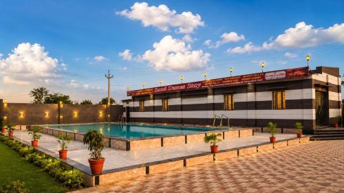 a swimming pool in front of a building at Sand Dunes Stay in Bagru