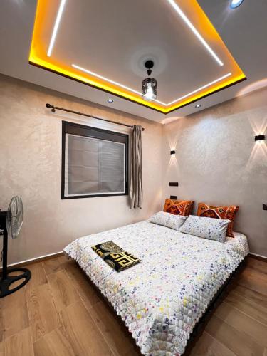 a bedroom with a bed with a yellow ceiling at Stoph in Beni Mellal
