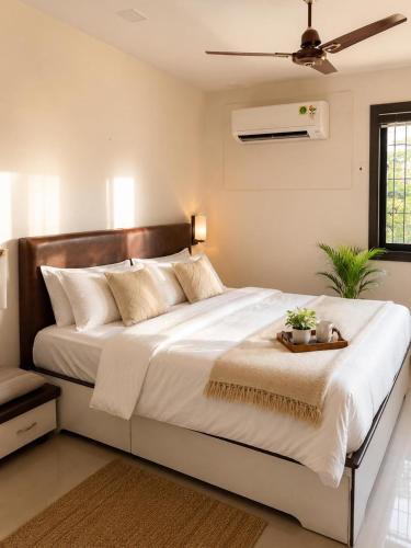 a bedroom with a large white bed with a tray on it at Vishwakarma Niwas Jacuzzi Villa with Pool in Thane