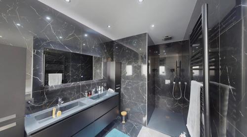 a black bathroom with a shower and a sink at Home cinema in Liège