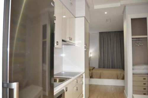 a kitchen with a sink and a refrigerator at Apartamentos Las Palmeras in Palma del Río