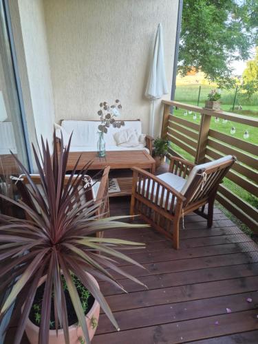 a patio with a table and chairs on a deck at Butas Karklėje in Karklė