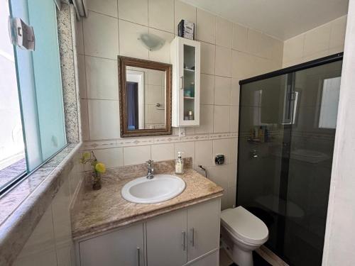 a bathroom with a sink and a shower and a toilet at Casa Costa do Sol completa, 100m da praia in Macaé