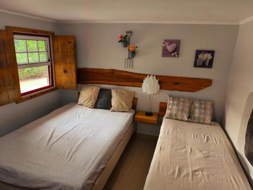 a bedroom with two beds and a window at De Baixo Da Ponte in Biscoitos
