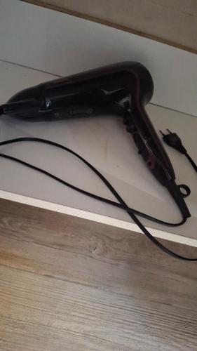 a black hair dryer sitting on top of a floor at Arvén Crimson in Marghera