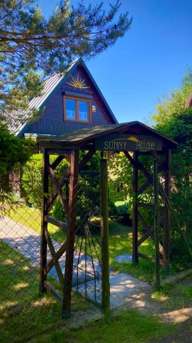 a small building with a sign in the grass at Sunny House Baltic in Kopalino