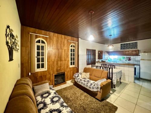 a living room with a couch and a kitchen at Casa da Neuza in Resende