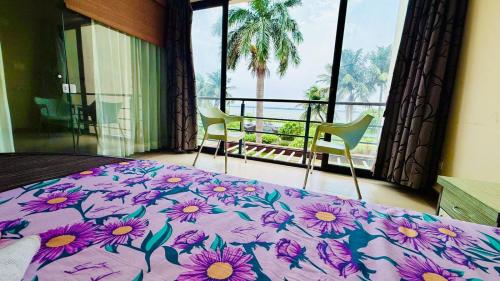 a bedroom with a bed and two chairs and a window at Tranquil villa Raichak in Diamond Harbour