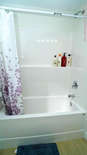 a white bath tub with a blue rug in a bathroom at The Ivory house in Prince George