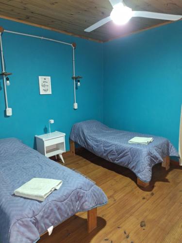 a room with two beds and a blue wall at Lo de La Abuela 1 in Goya