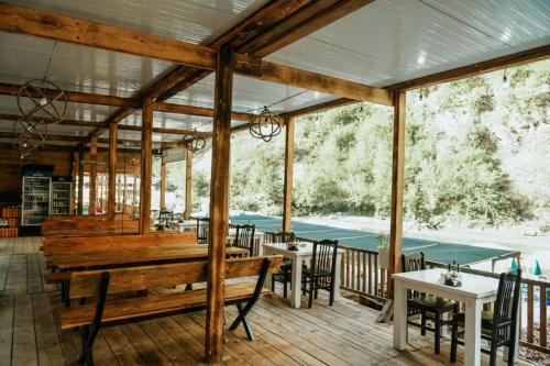 a pavilion with tables and benches on a deck at Gio Camping Shala River in Mollʼ e Shoshit