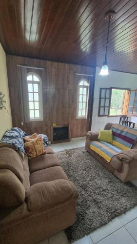 a living room with a couch and a fireplace at Casa da Neuza in Resende