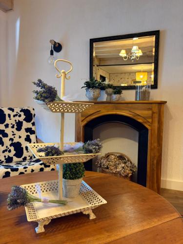 a living room with a fireplace and a mirror at L'Esprit Cottage in La Tranclière