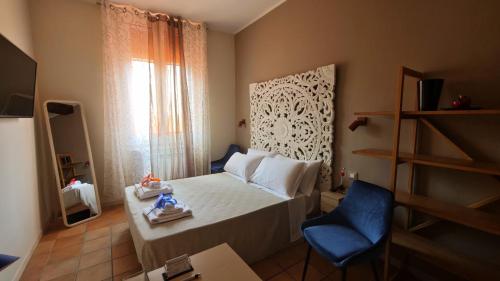 a small bedroom with a bed and a blue chair at Montefiori Luxury Suite & Spa in Bologna