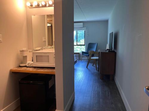 a room with a kitchen with a sink and a microwave at Sechelt inn in Sechelt