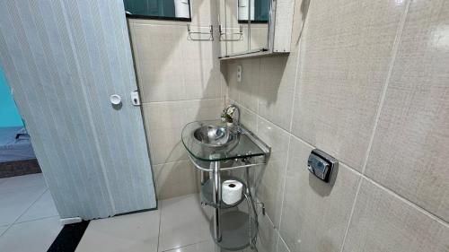 a small bathroom with a sink and a mirror at Apartamento com piscina privativa 7 minutos da basílica in Aparecida