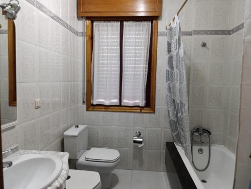 a bathroom with a toilet and a sink and a shower at Hostal La Madrileña in La Gudiña