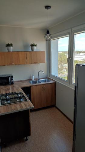 a kitchen with a sink and a refrigerator at SkyView Studio Łódź - 11th Floor - Free Parking in Łódź
