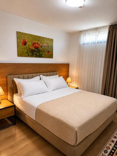 a bedroom with a bed and a painting on the wall at 313 Villa City Center in Tirana