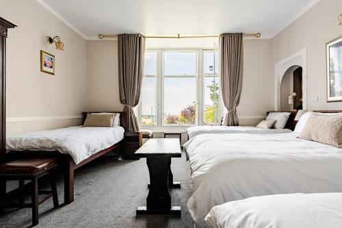 a bedroom with three beds and a window at Edinburgh Beach in Edinburgh