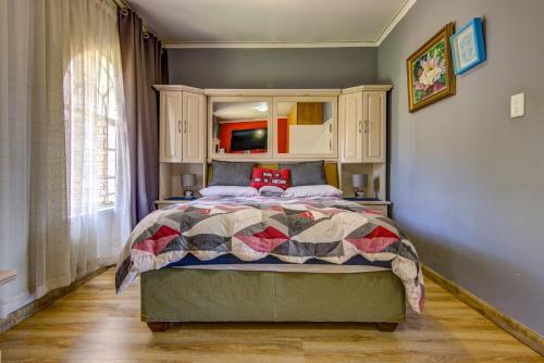a bedroom with a bed with a quilt on it at Kempton kingdom in Kempton Park