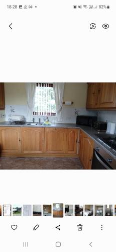 a kitchen with wooden cabinets and a window at The Braes in Stornoway