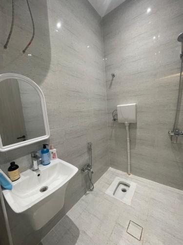 a bathroom with a sink and a mirror and a toilet at المجيدل للشقق المفروشة in Arar