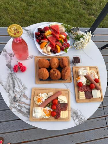a table with plates of food and a plate of fruit at Džipsi glamping resort in Sarajevo