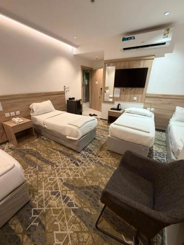 a hotel room with two beds and a couch at فندق اليسر الفضي ام القري in Mecca
