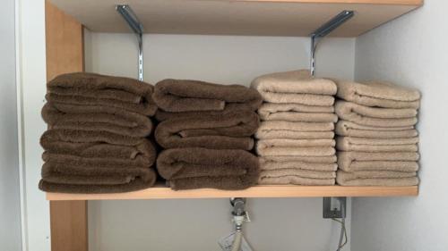 a bunch of towels are on a shelf at ファミリーロッジ つつじ in Sakaiminato