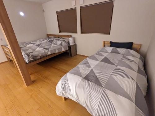 a bedroom with two twin beds in a room at ファミリーロッジ つつじ in Sakaiminato