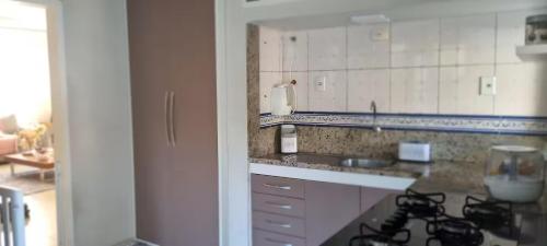 a kitchen with a stove and a counter top at Quarto Pernoite Costa do Sol in Macaé